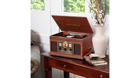 Victrola 6 in 1 Bluetooth Nostalgic on a table next to a vase