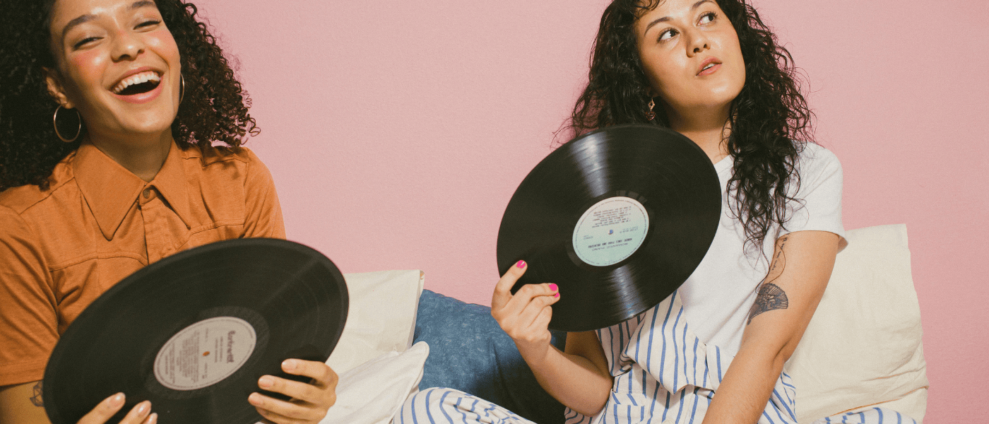 2 girls laughing and holding vinyl records