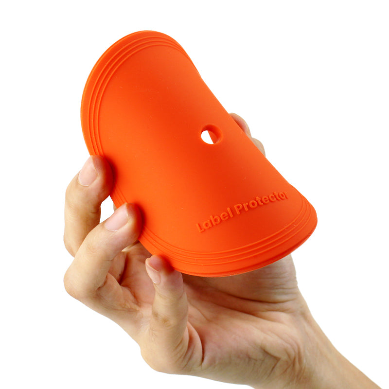 A hand holding a silicone orange record label protector