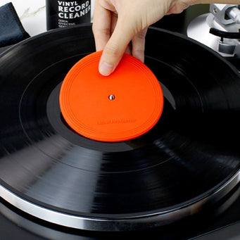 A hand placing a vinyl record label protector onto a record
