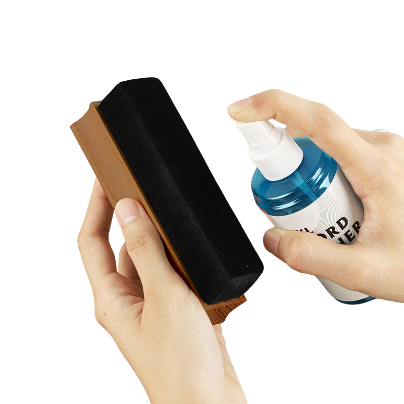 Hand holding record cleaning spray bottle spraying the velvet LP cleaning brush.