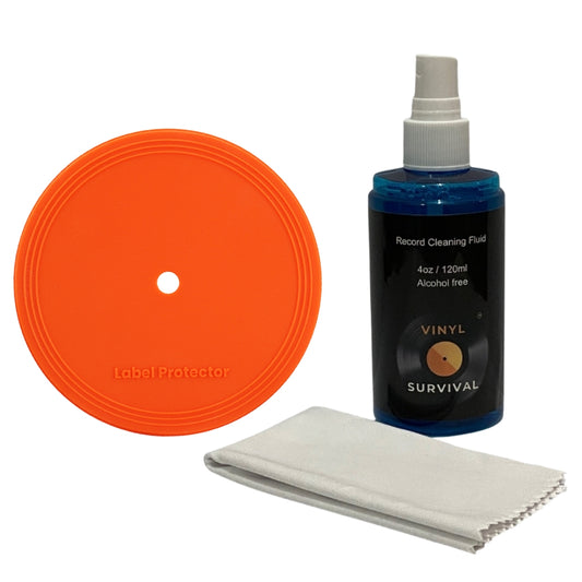 Vinyl Survival Record Cleaning Fluid kit including an orange circular label protector, a blue bottle of cleaning fluid, and a white microfiber cloth on a white background.