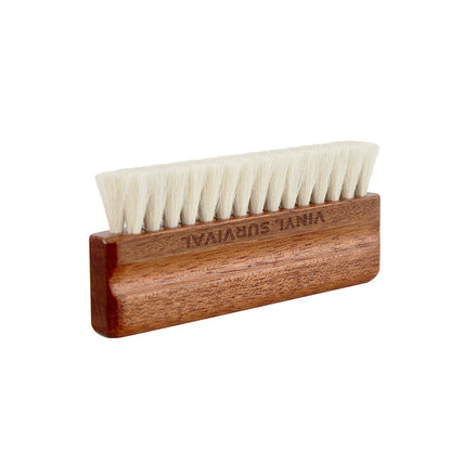 Vinyl Survival natural goat hair record cleaning bristle brush with name etched on brush. Standing horizontal at a slight angle.